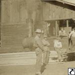 Men standing outside mill with 0-4-0 #1 "Yellow Hammer" in the background.