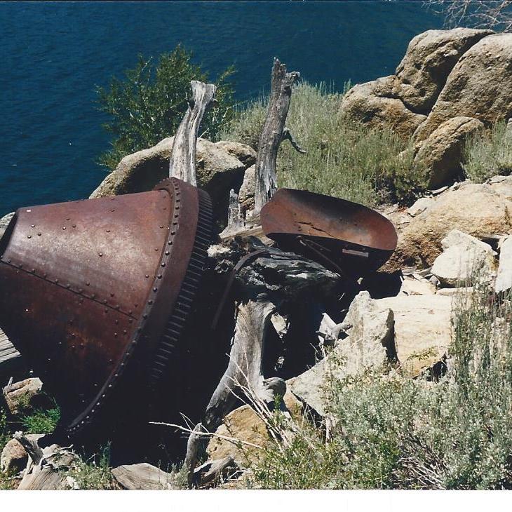 Relief dam concrete mixer and scrapper